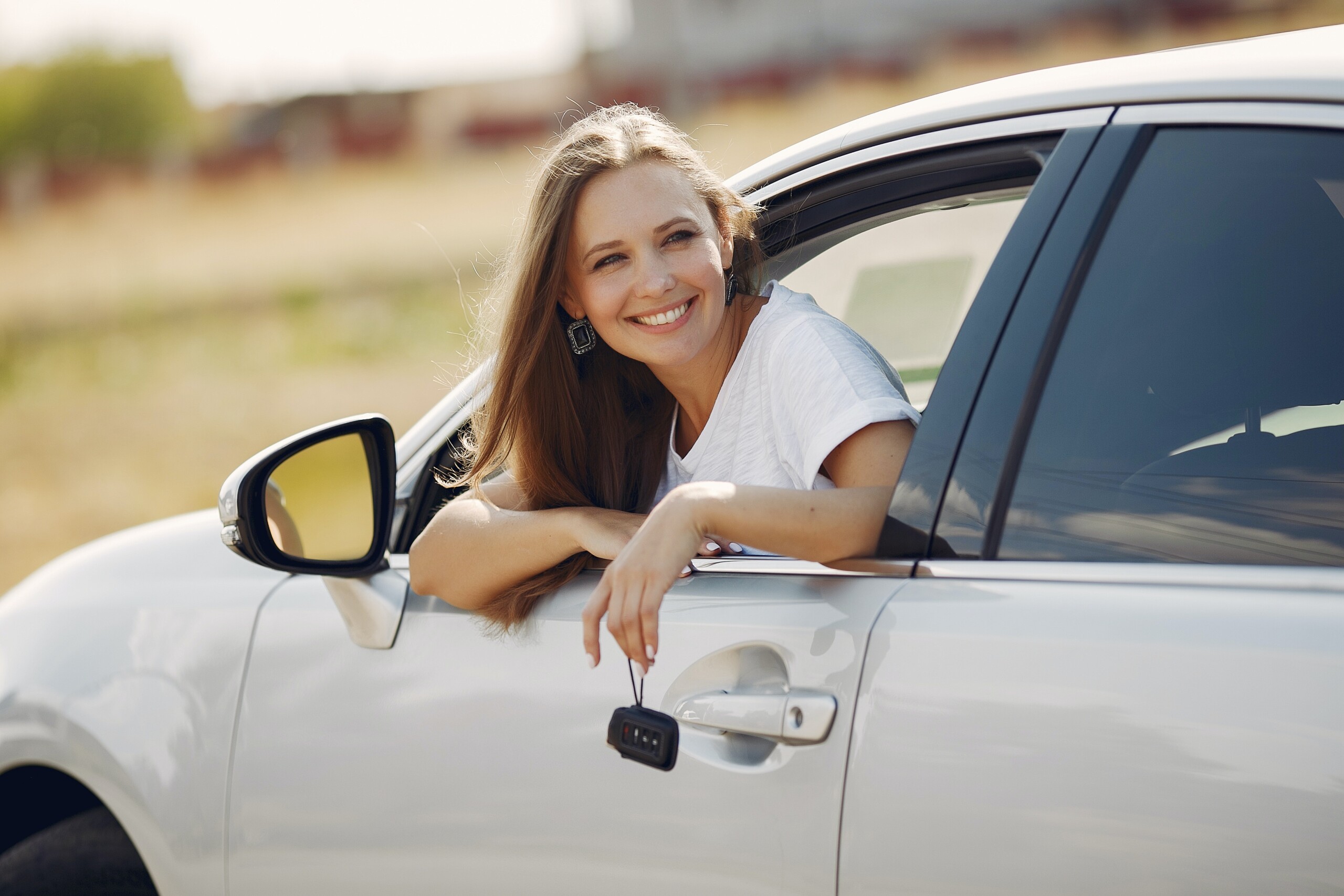 happy-woman-with-car-key-in-modern-automobile-during-car-4173099