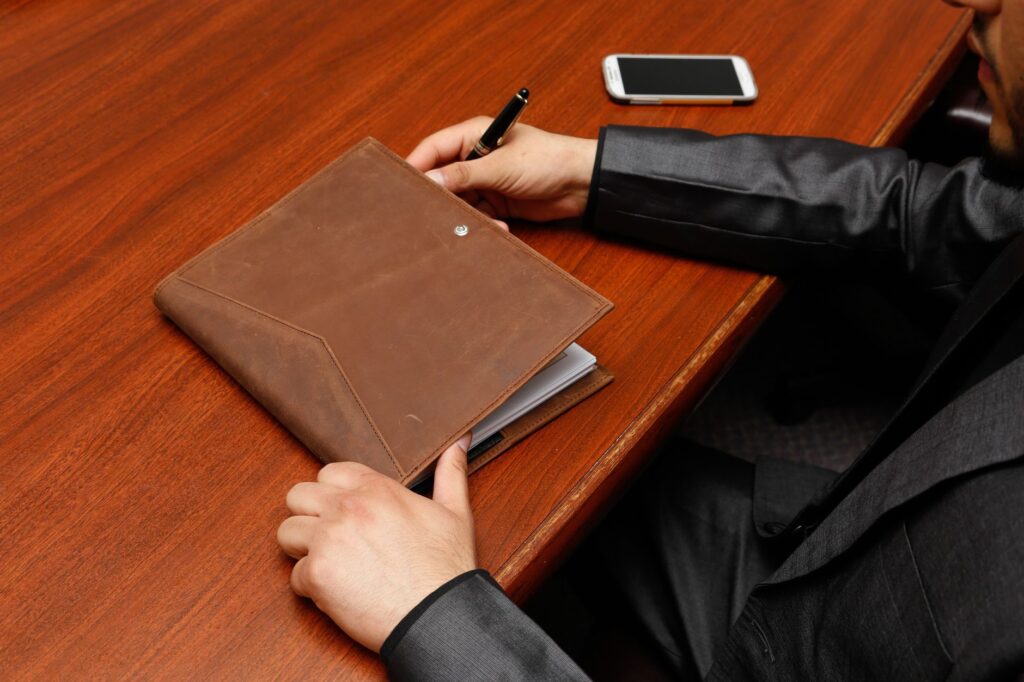 person holding brown leather book